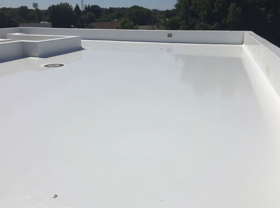 A newly coated flat roof with a smooth white reflective surface