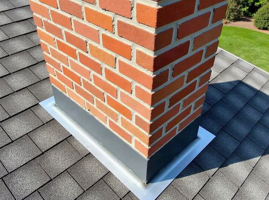Step and counter flashing around a brick chimney on a shingle roof