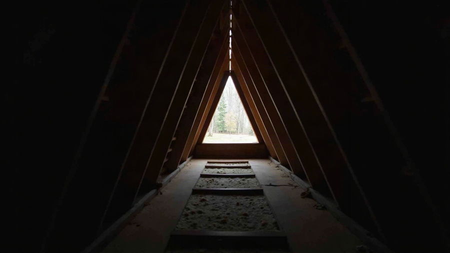 Daylight showing through a gap in roof decking seen from inside an attic