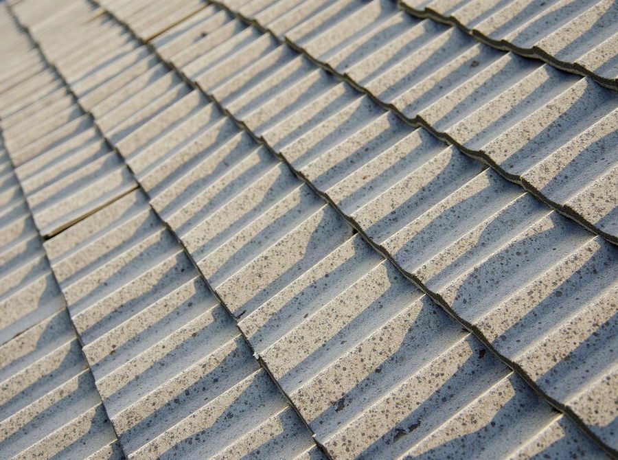 Flat concrete roof tiles laid in even courses on a pitched roof